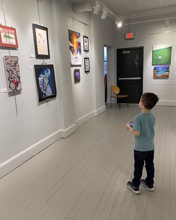 Image of a child looking at art on a wall