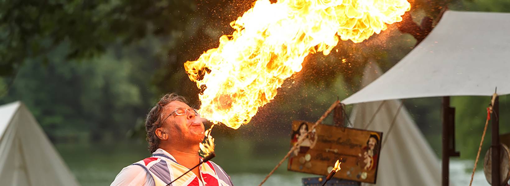 Man breathing fire at a campground