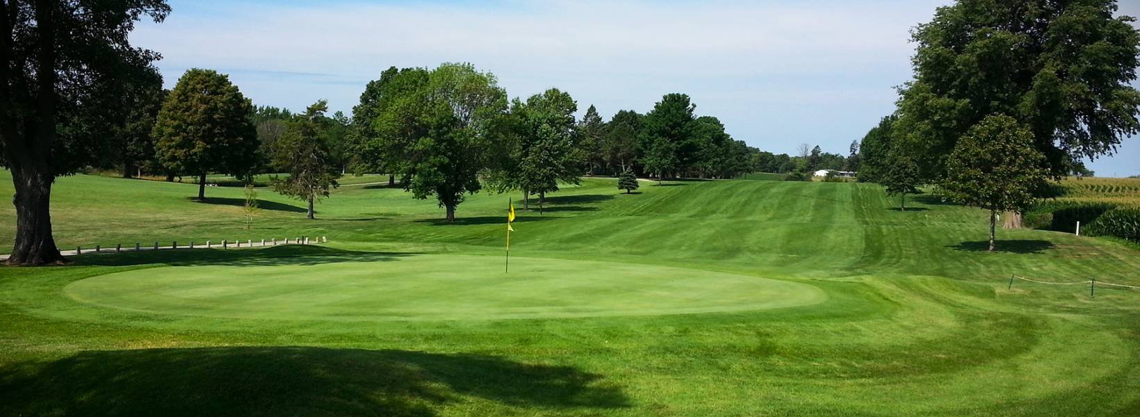 Golf course fairway with trees and blue sky