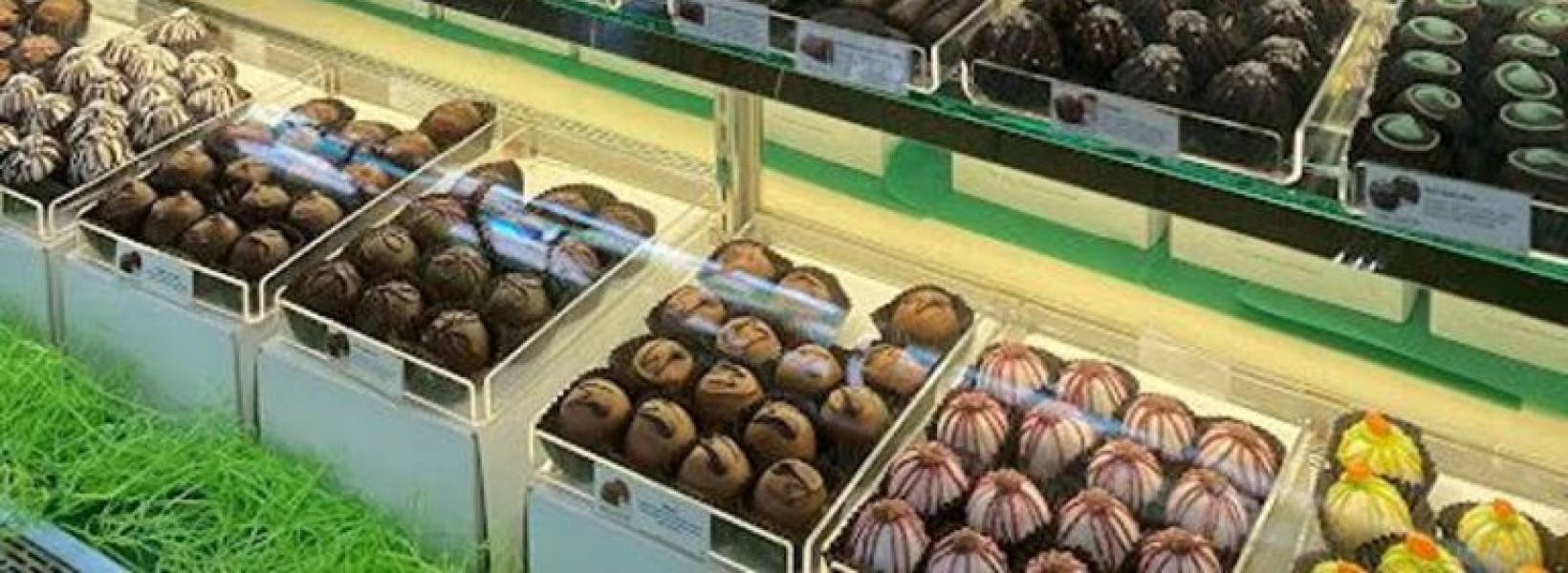 Image of a woman behind a counter full of chocolate treats